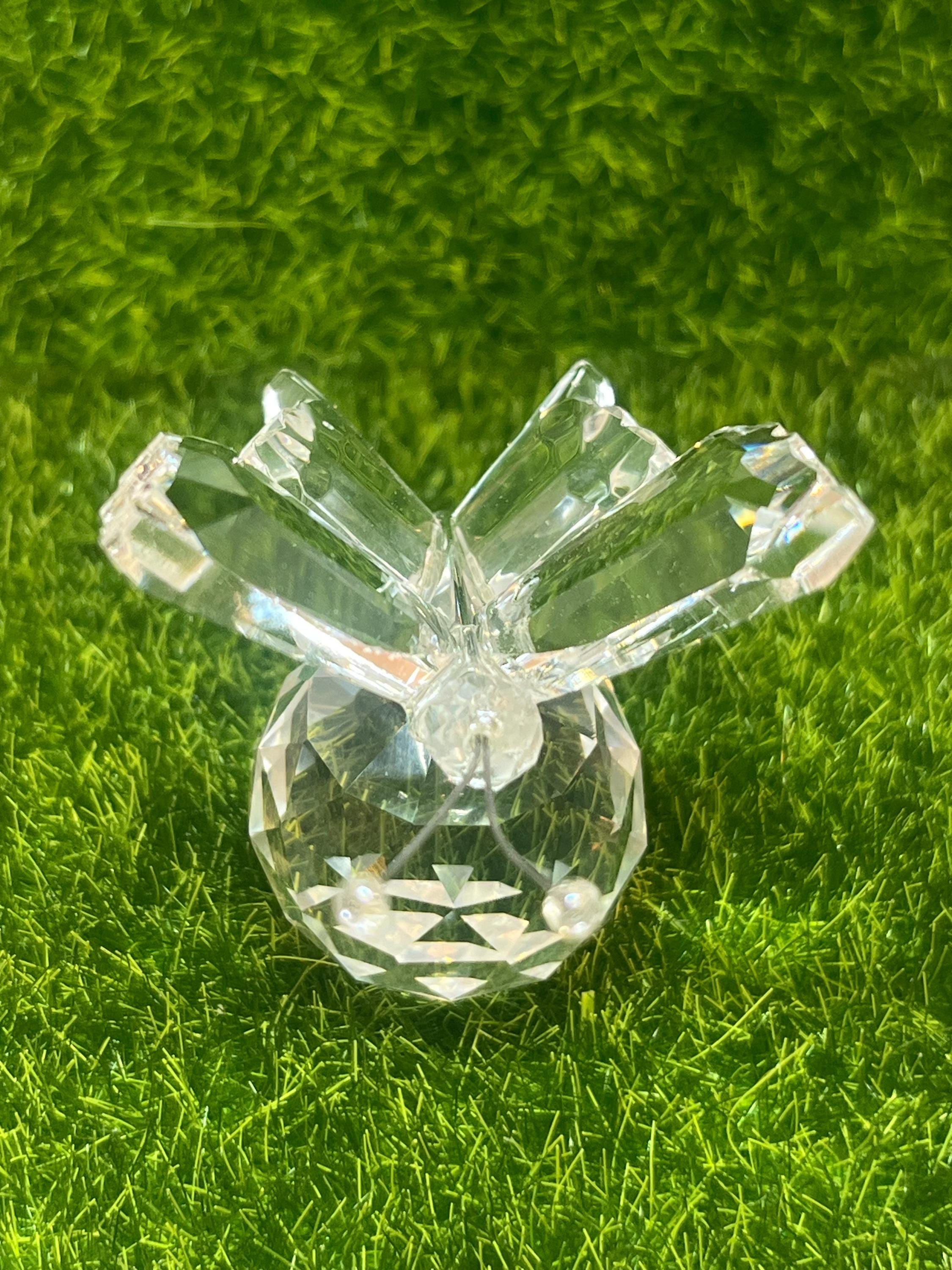 Clear crystal snowflake figurine on a green textured background