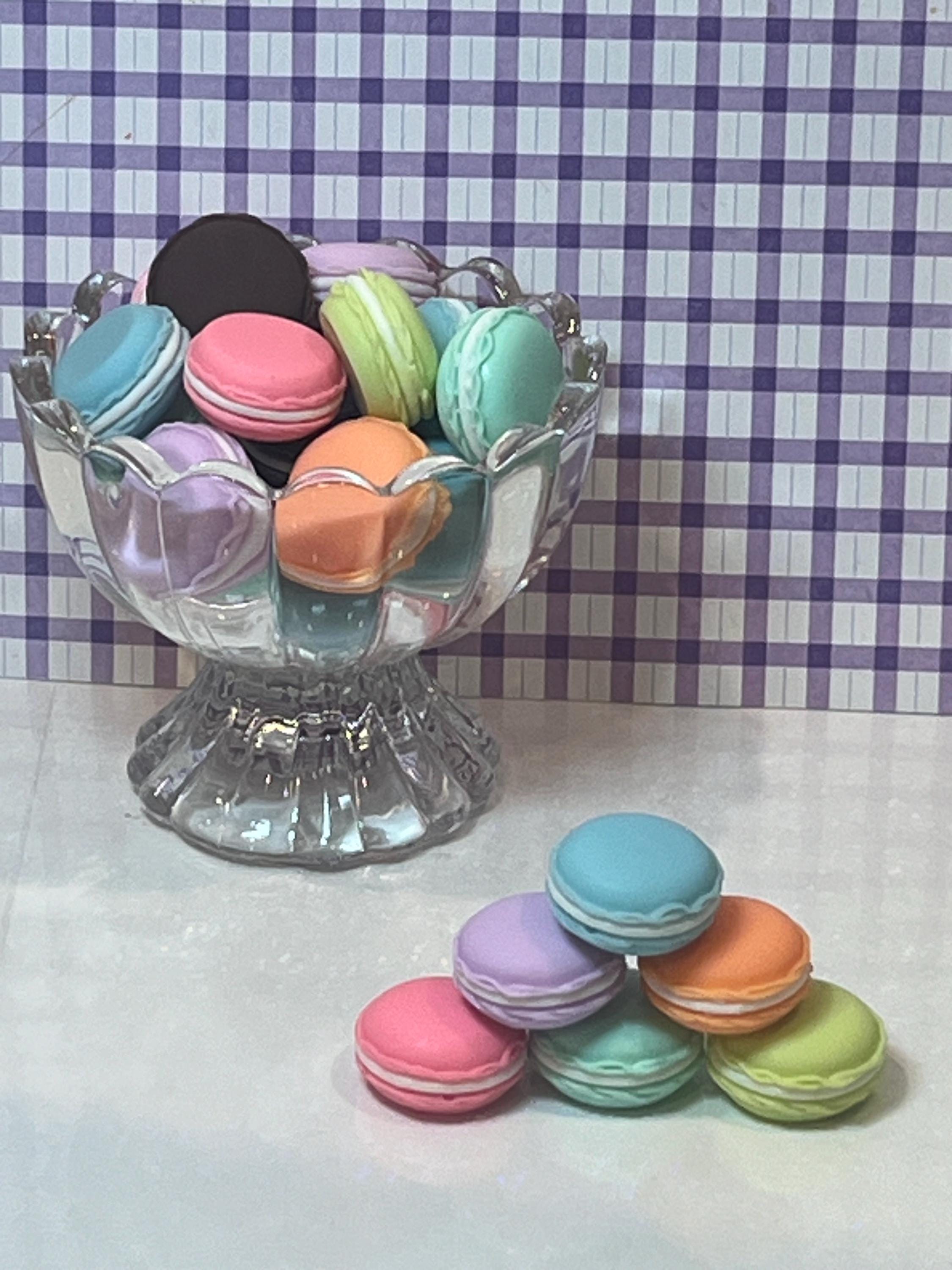 Colorful macarons in a glass dish with a checkered background