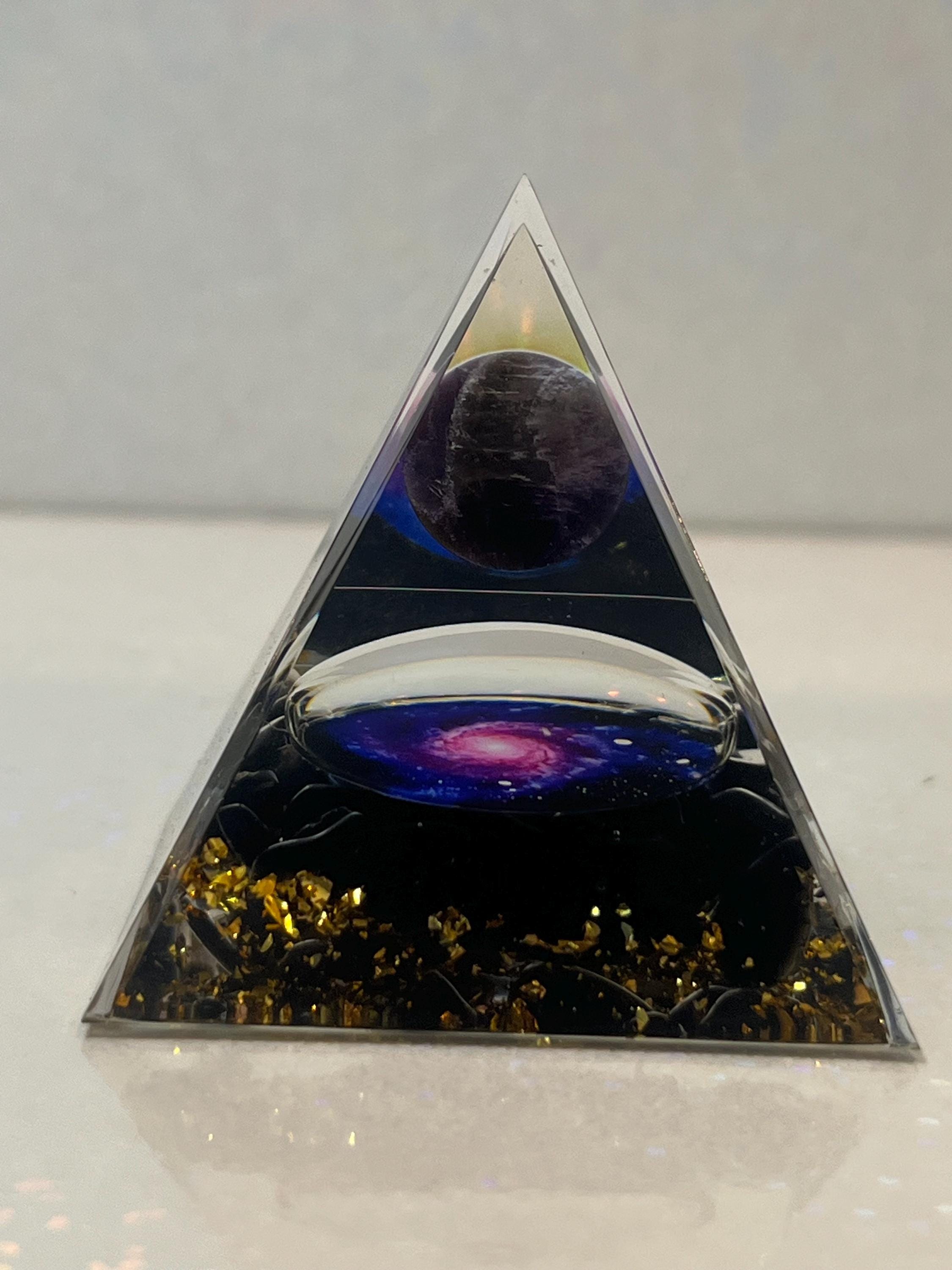 Triangular pyramid with a reflective surface showing cosmic scene