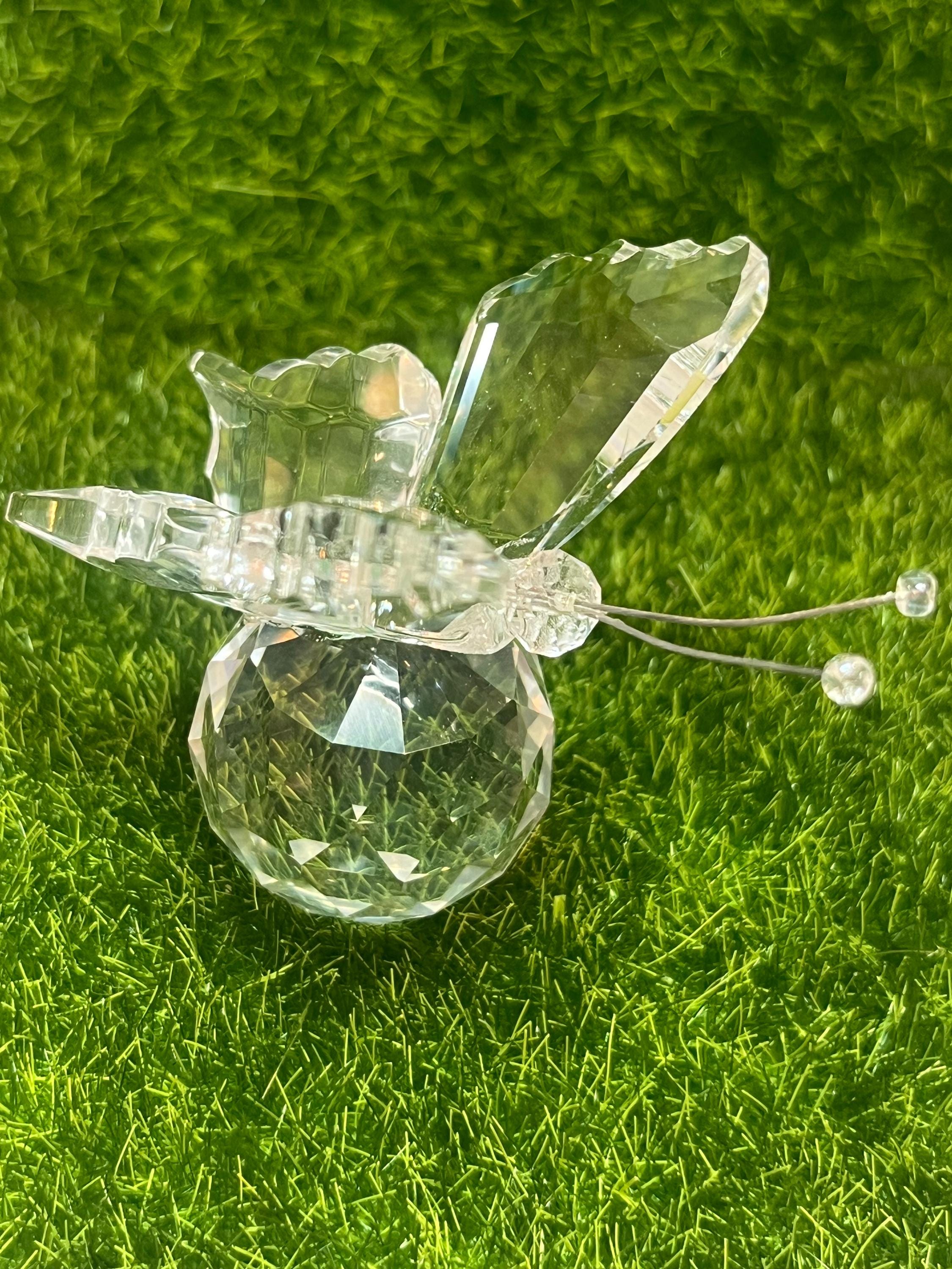 Clear butterfly figurine on a green grass background