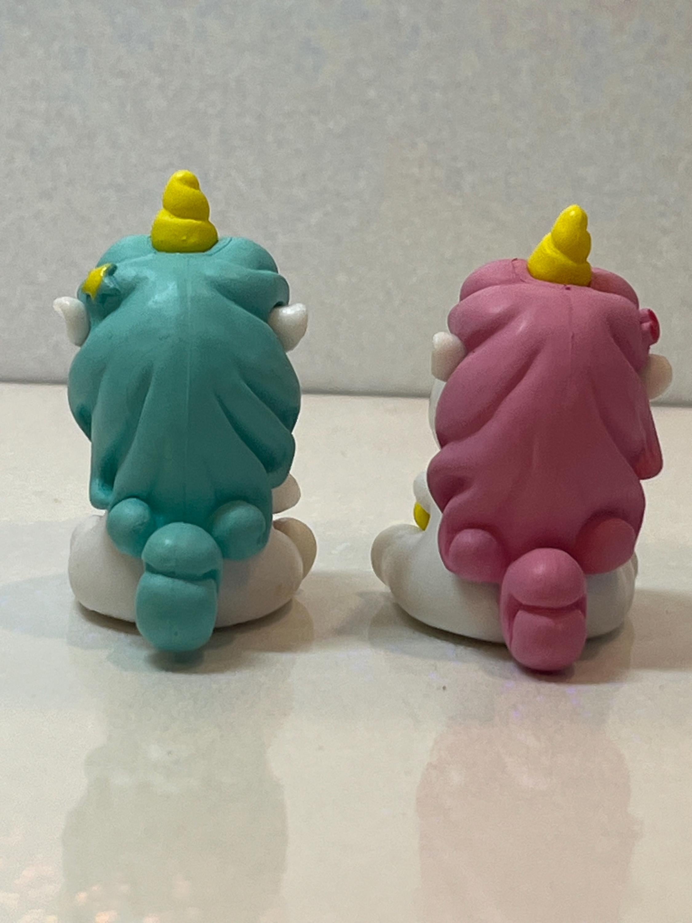Two colorful gnome figurines with rainbow hair on a light background