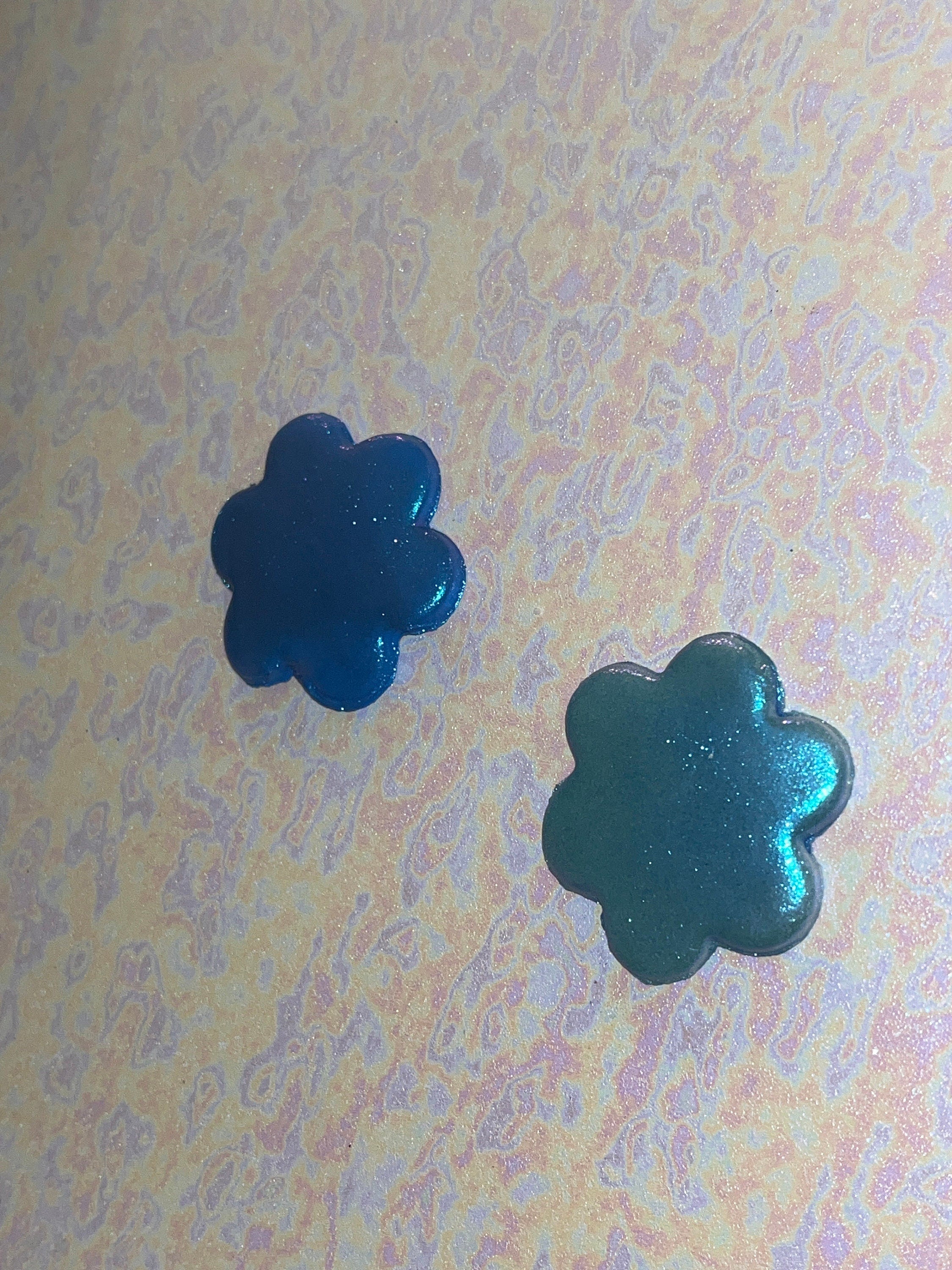 Two blue flower-shaped objects on a patterned background