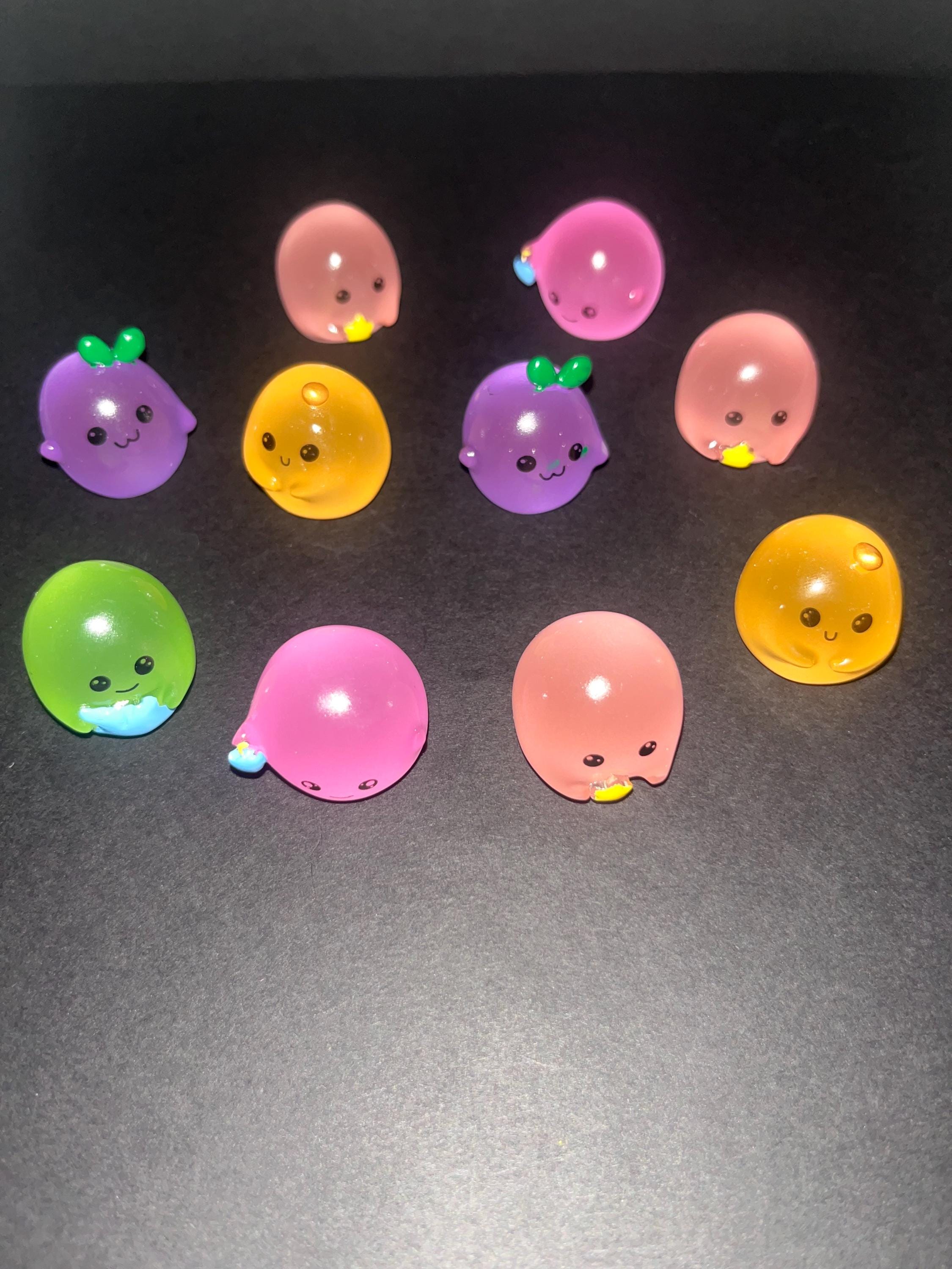 Colorful cartoon-style fruit figurines on a dark surface