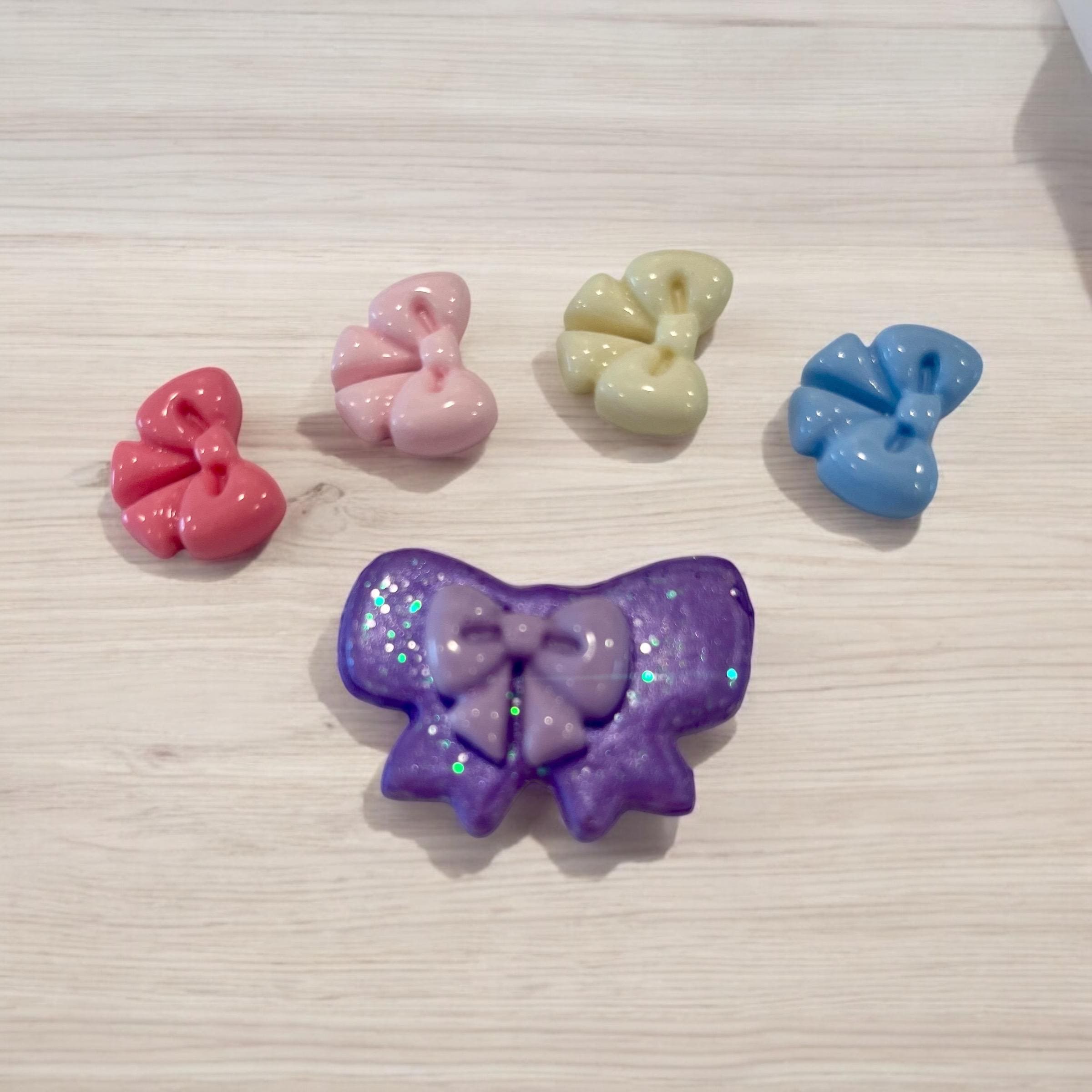 Set of colorful bow-shaped hair accessories on a light wooden surface