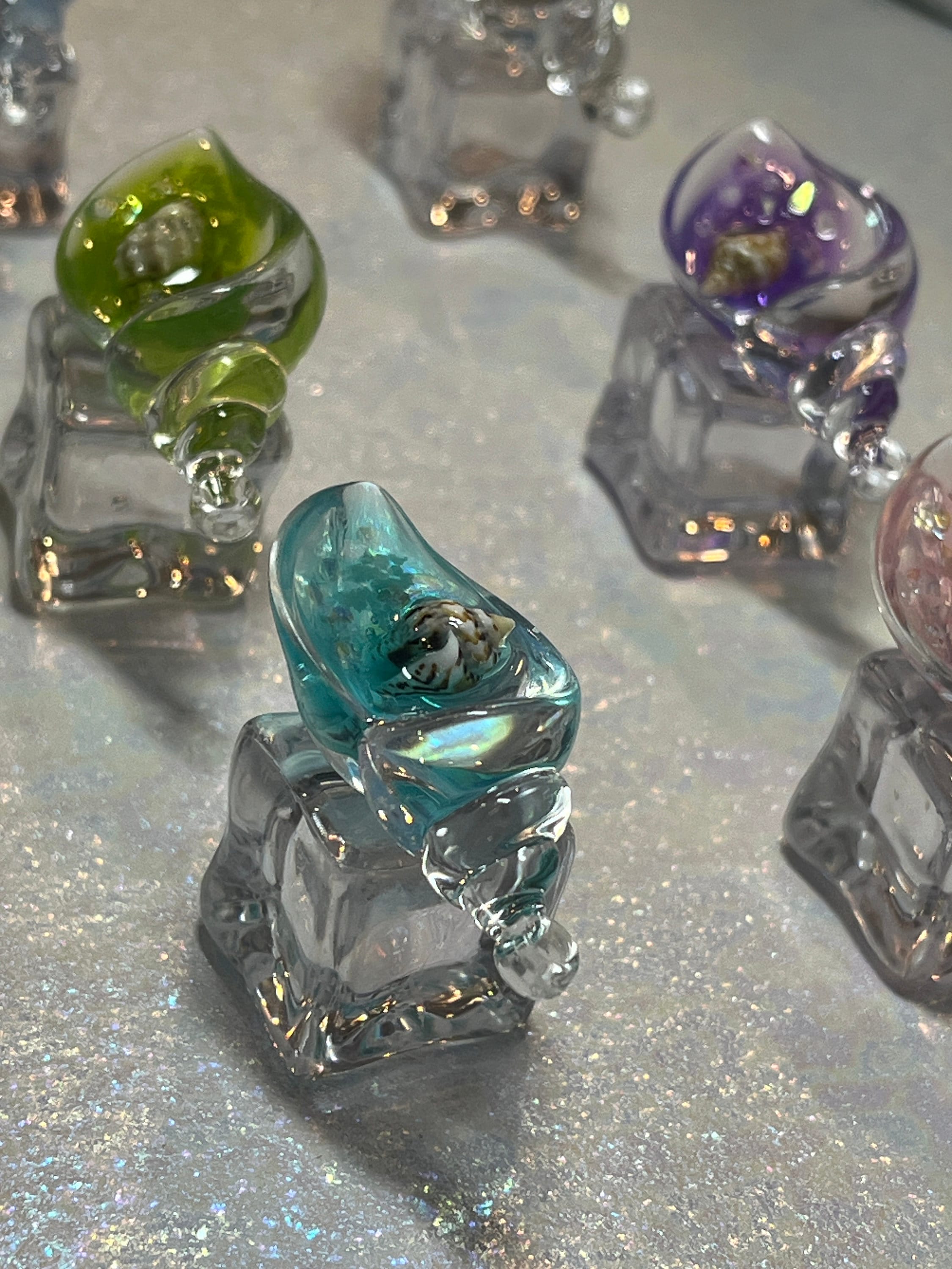 Colorful glass sculptures on a reflective surface