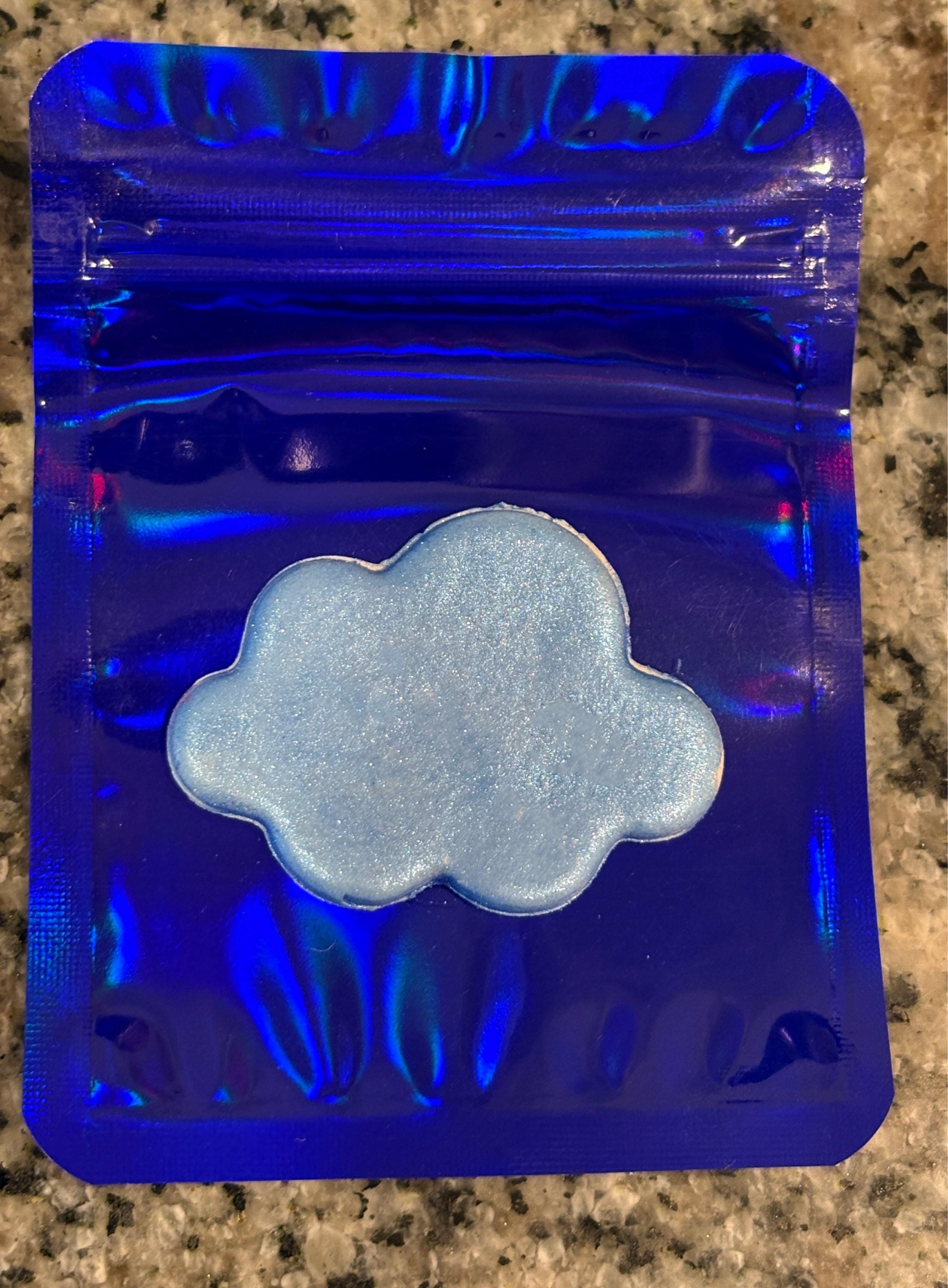 Blue transparent packaging with a cloud-shaped object on a textured surface