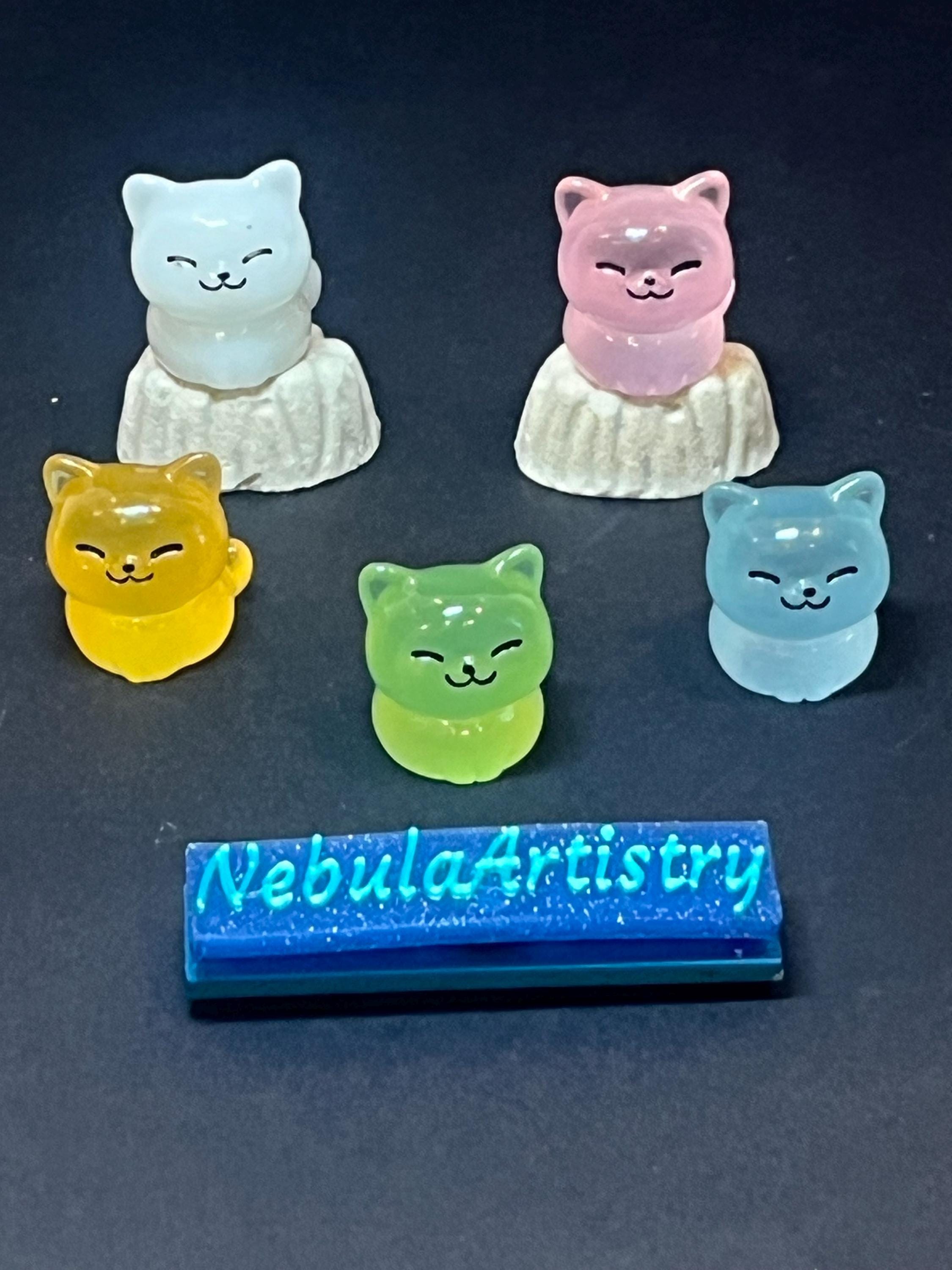 Set of colorful cat-shaped night lights with 'Nebula Artistry' branding on a dark background.