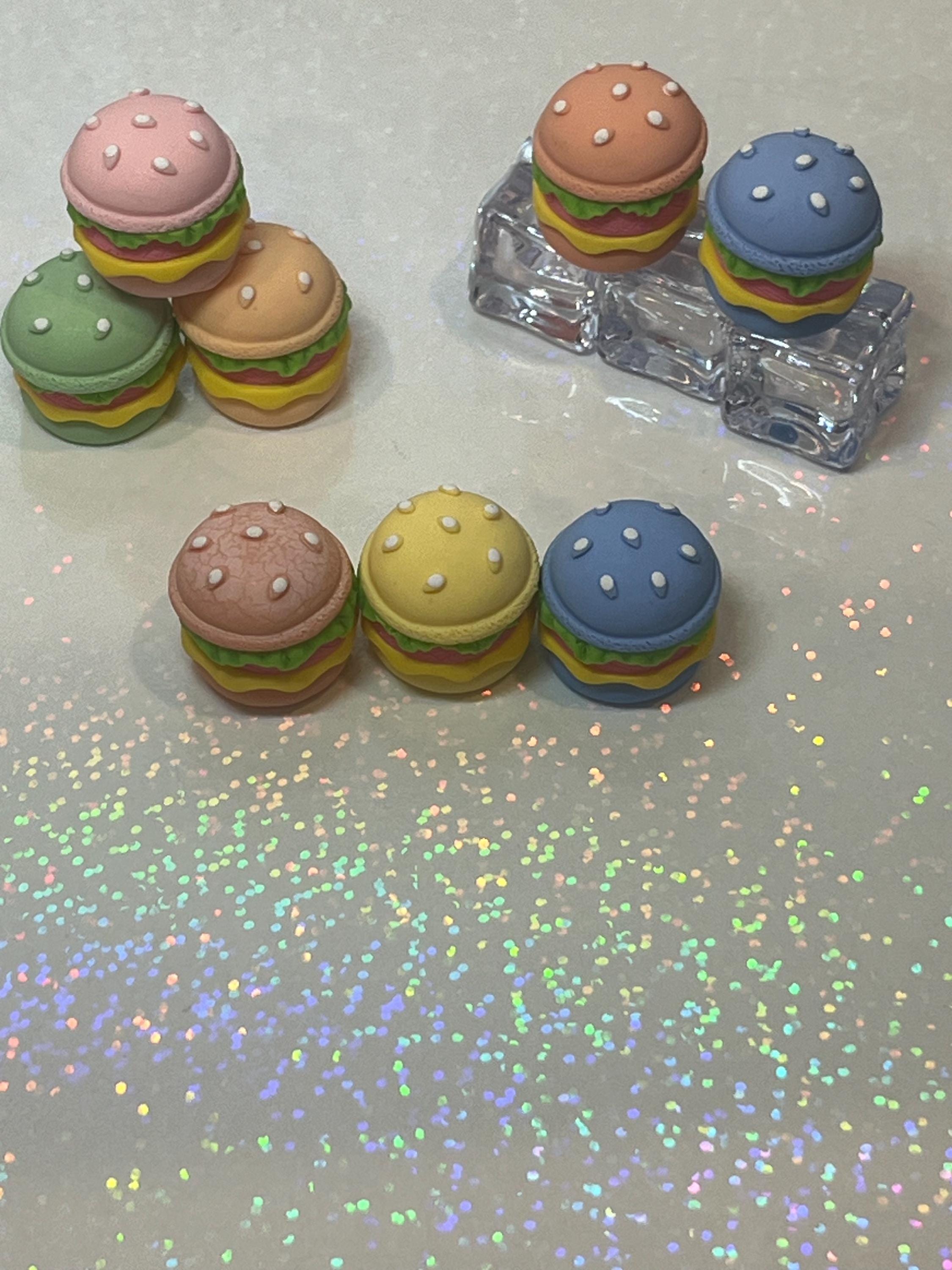 Colorful hamburger-shaped erasers on a reflective surface