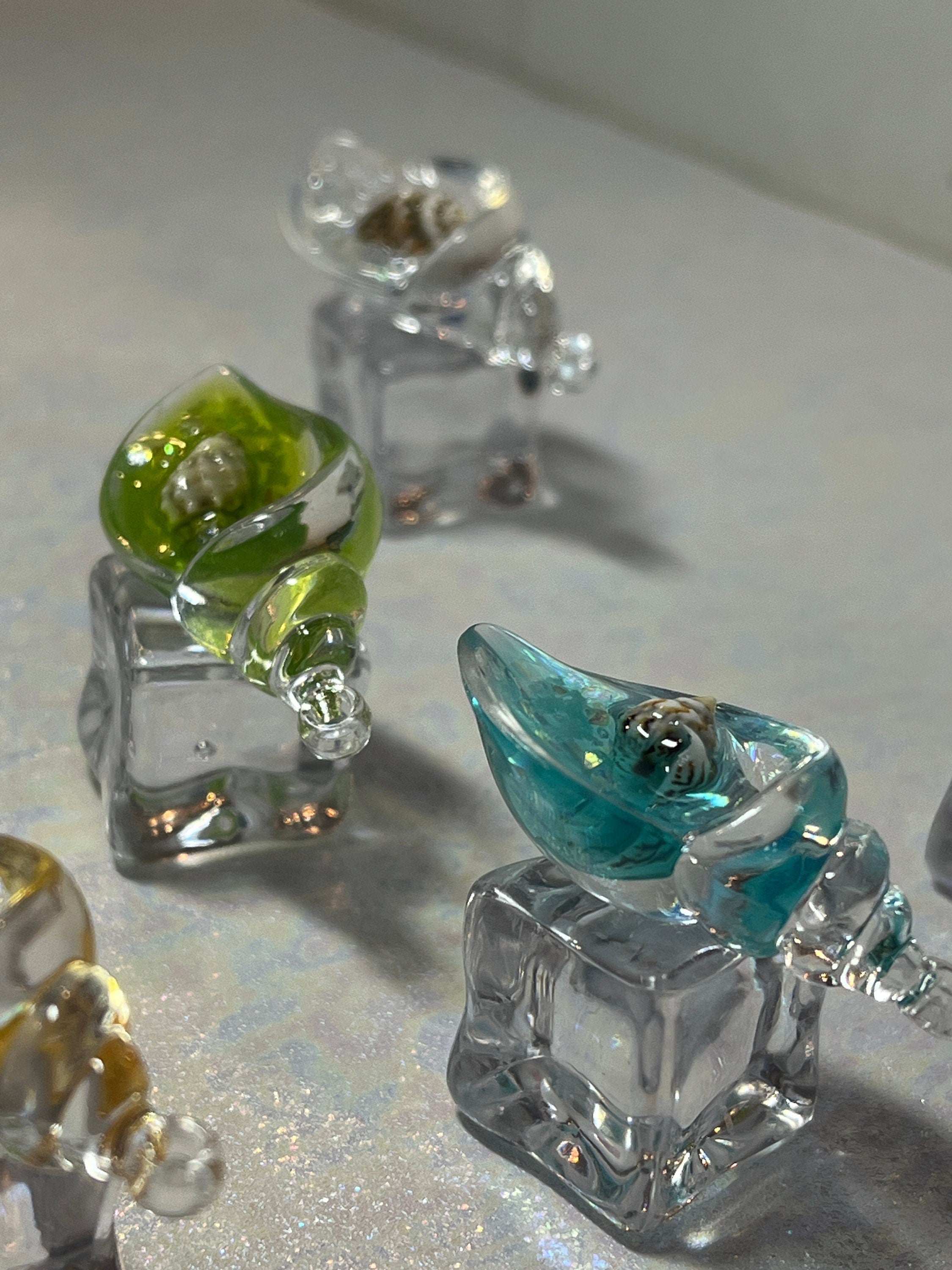 Small glass figurines on a reflective surface