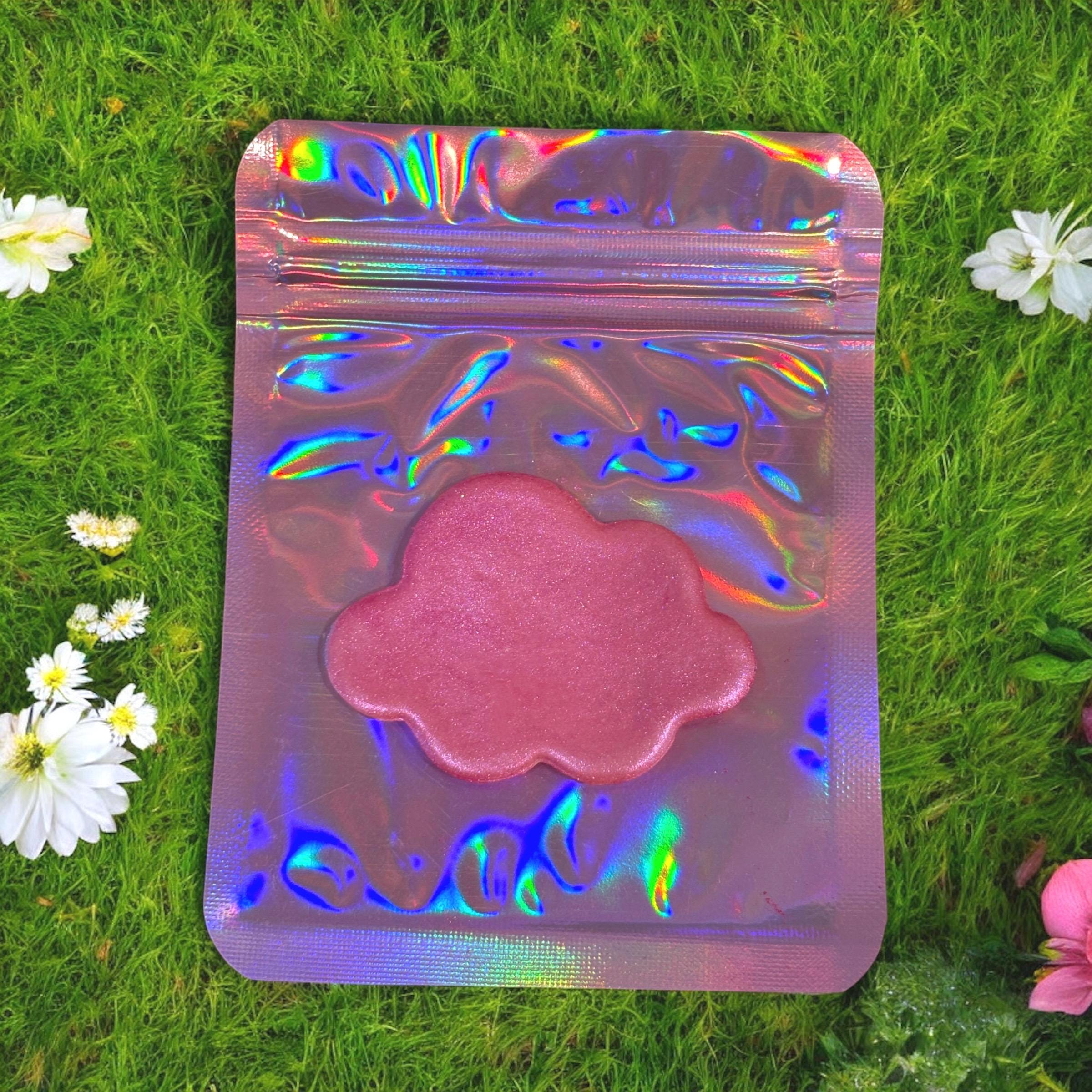 Holographic pink packaging on grass with flowers