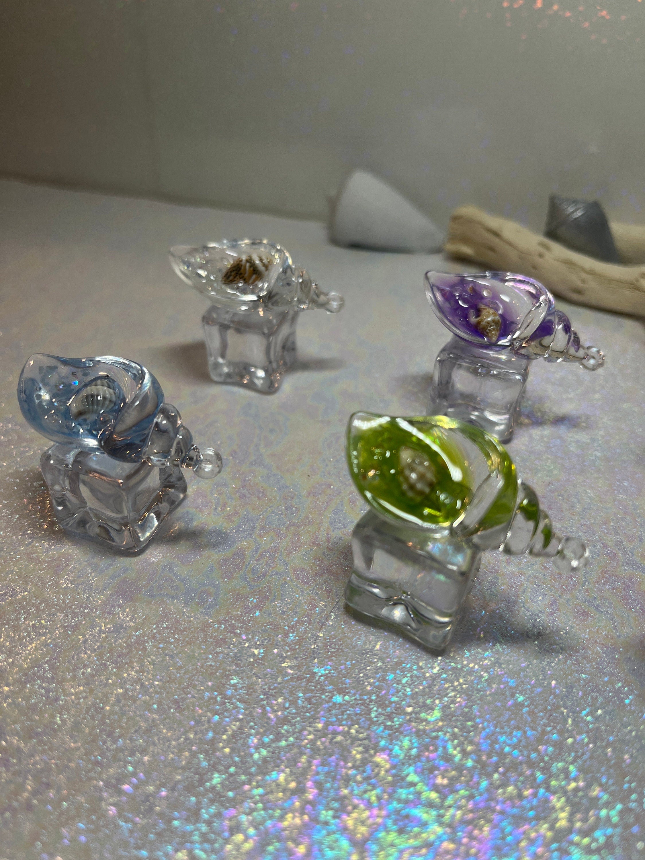 Set of small glass figurines on a reflective surface with a blurred background