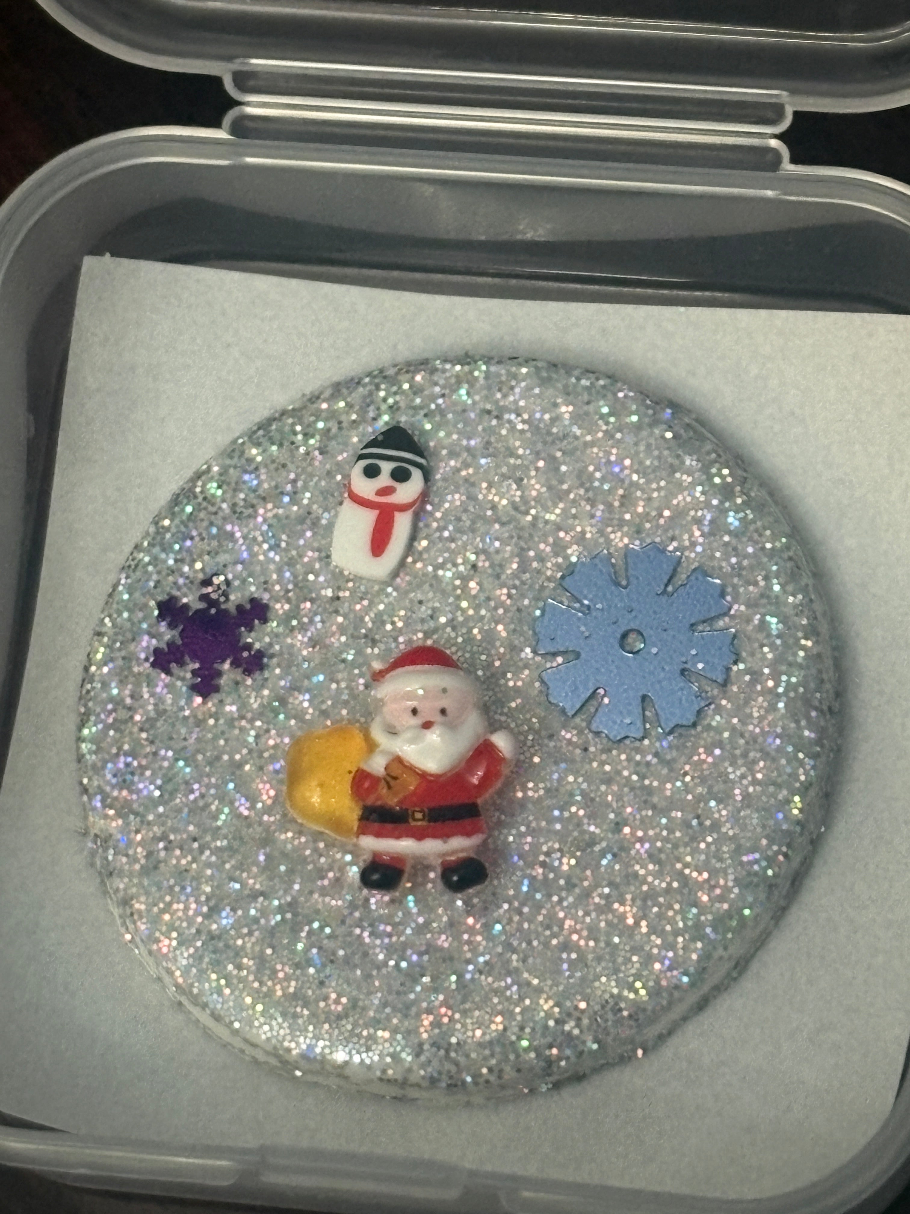 Decorative item with glitter, snowflakes, and a snowman figure inside a clear container.