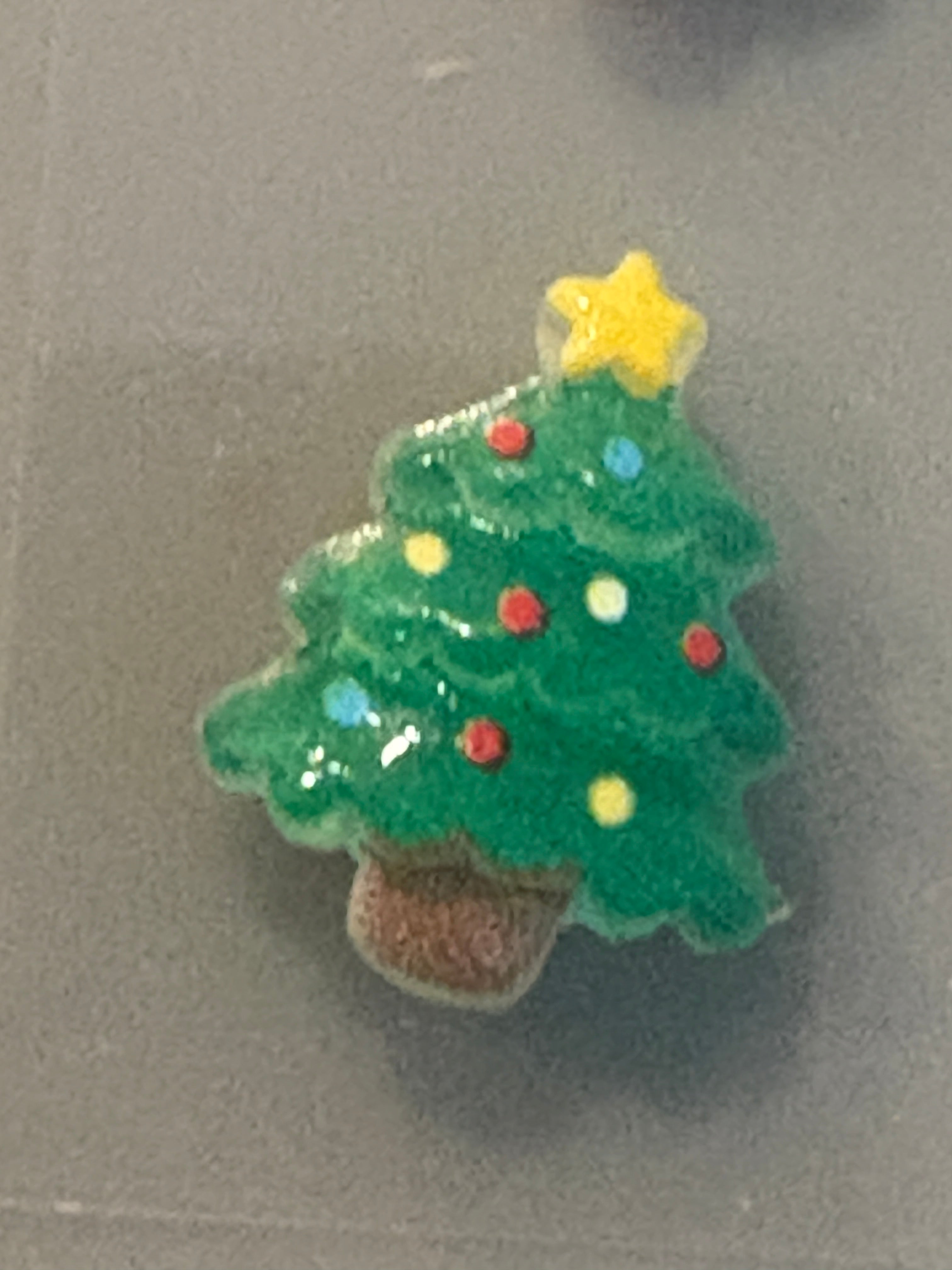 Small Christmas tree decoration with colorful ornaments on a gray background