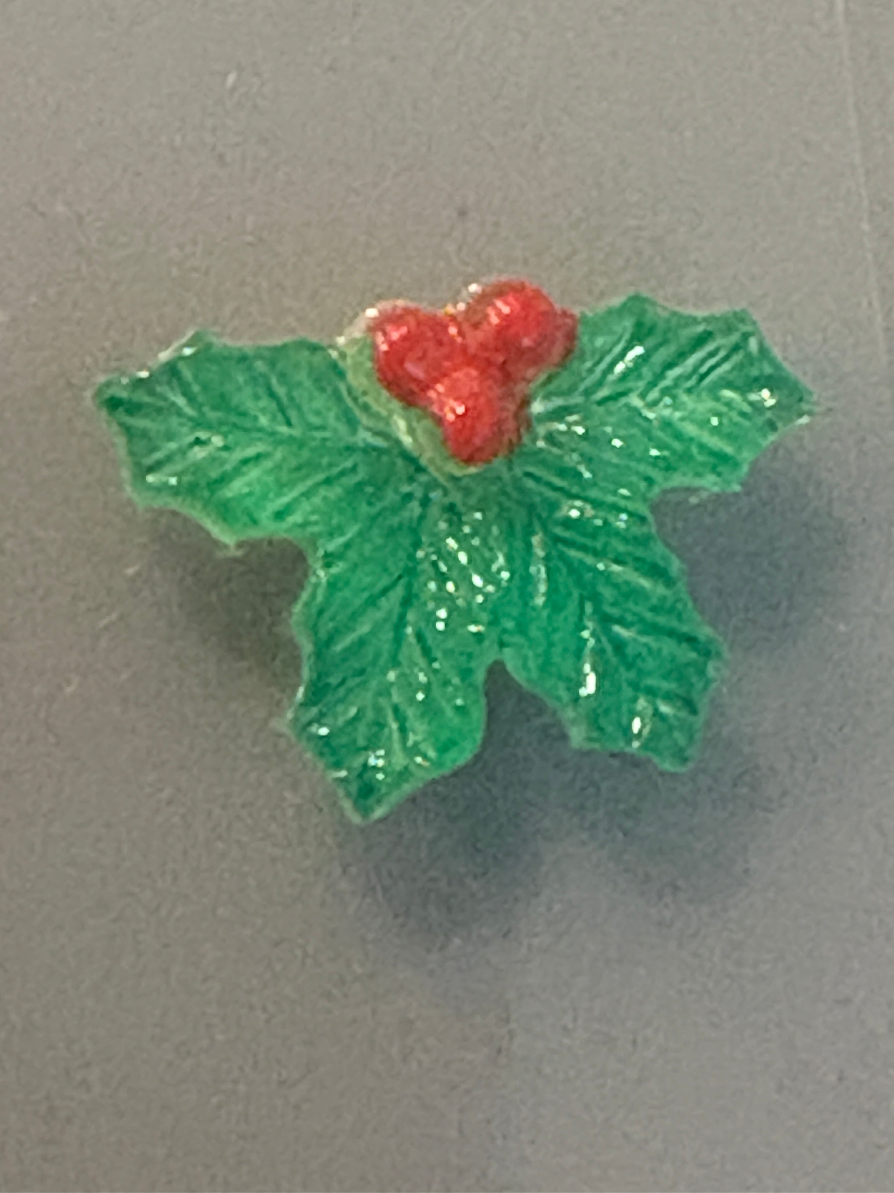 Decorative holly leaf with red berries on a gray background