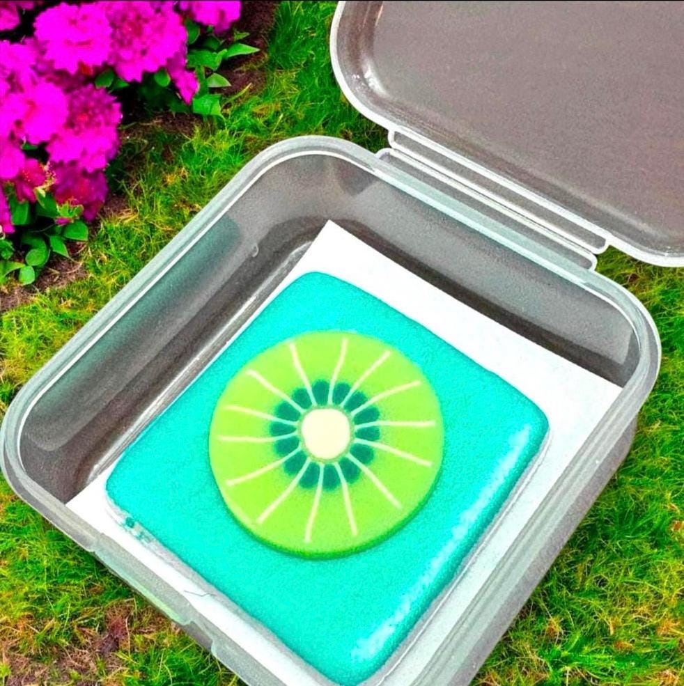 Clear container with a green kiwi slice design on a grassy background