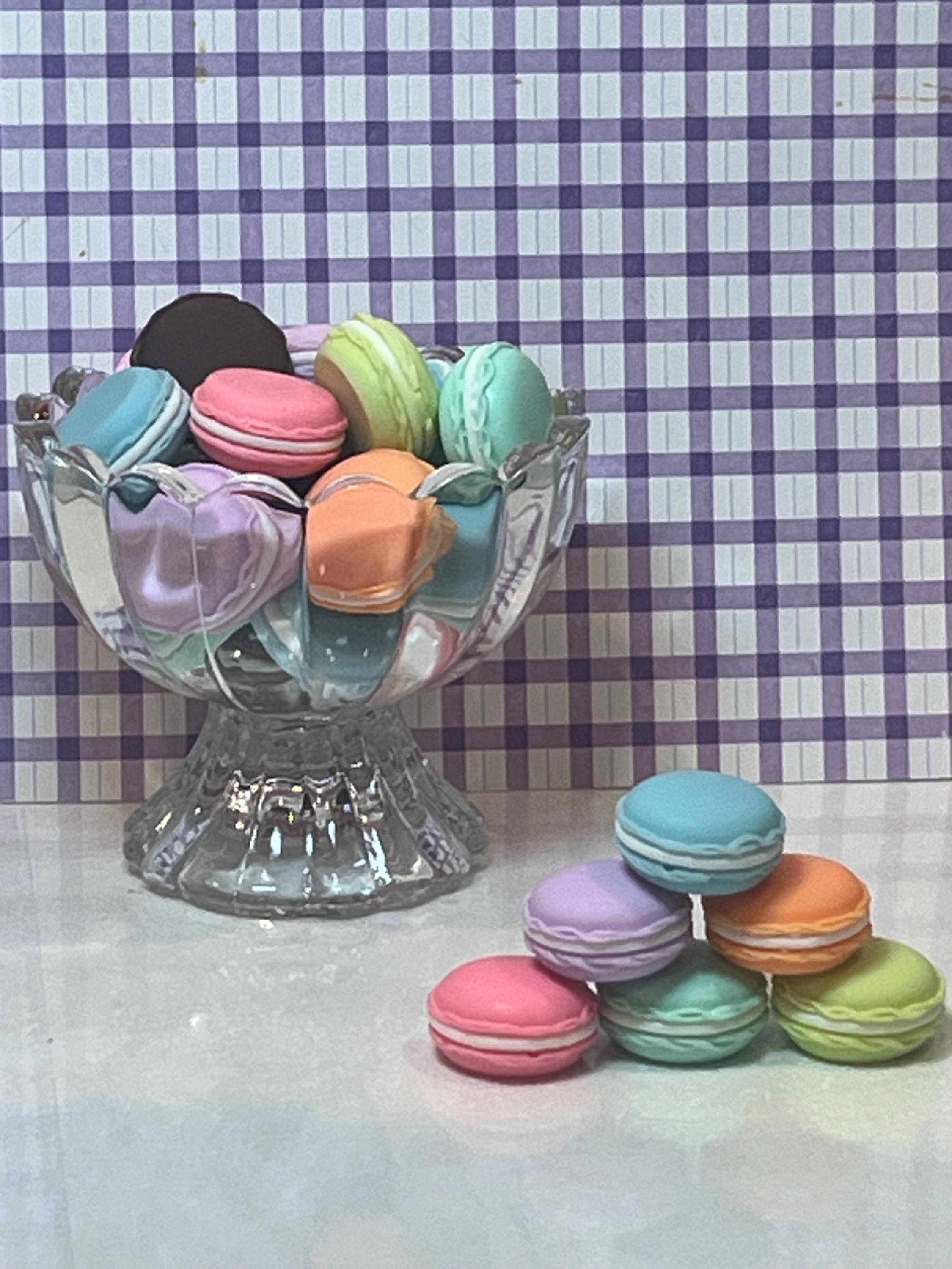 Pastel-colored macarons in a glass dish with a checkered background