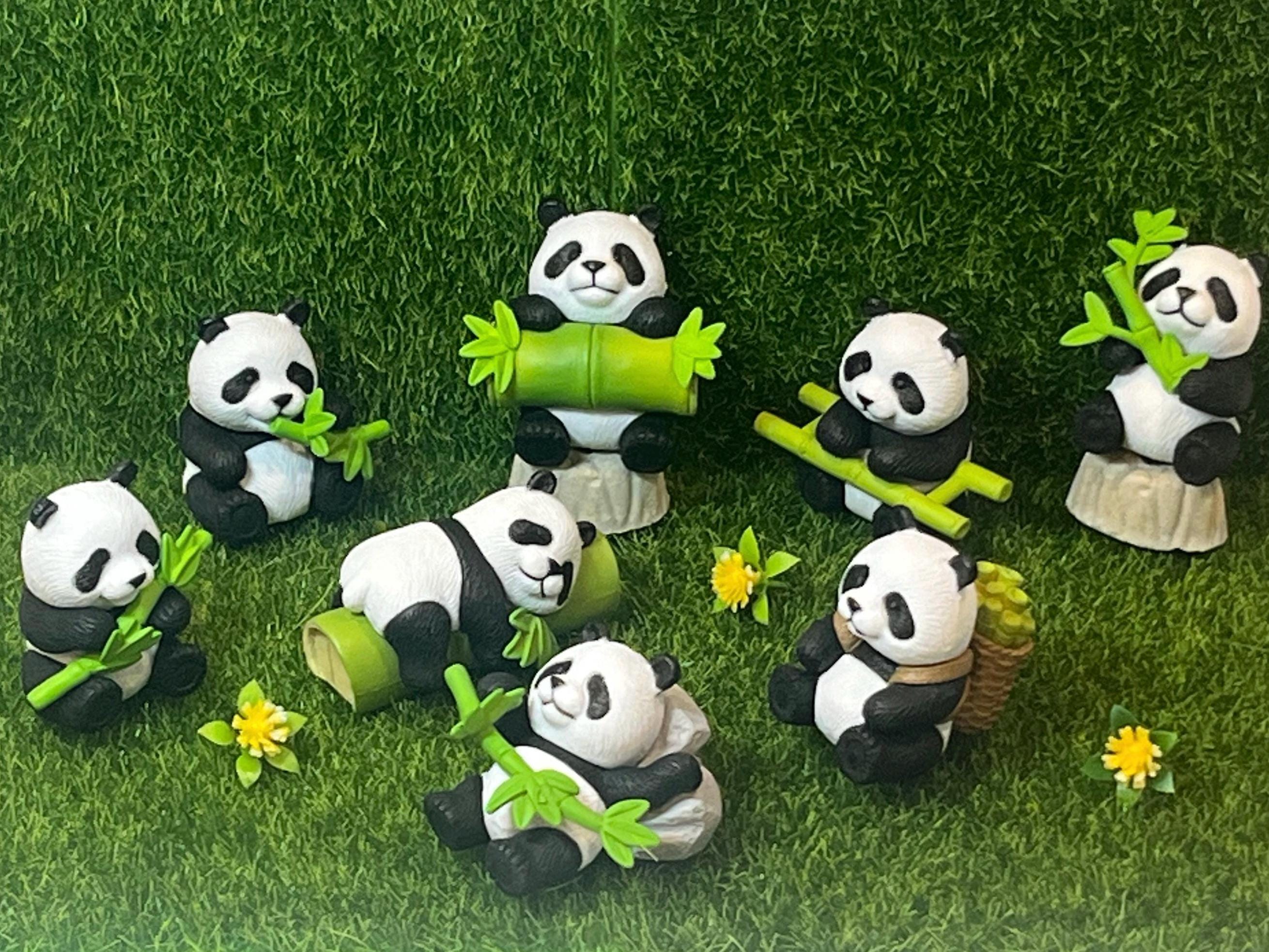 Set of panda figurines with bamboo on a grassy background