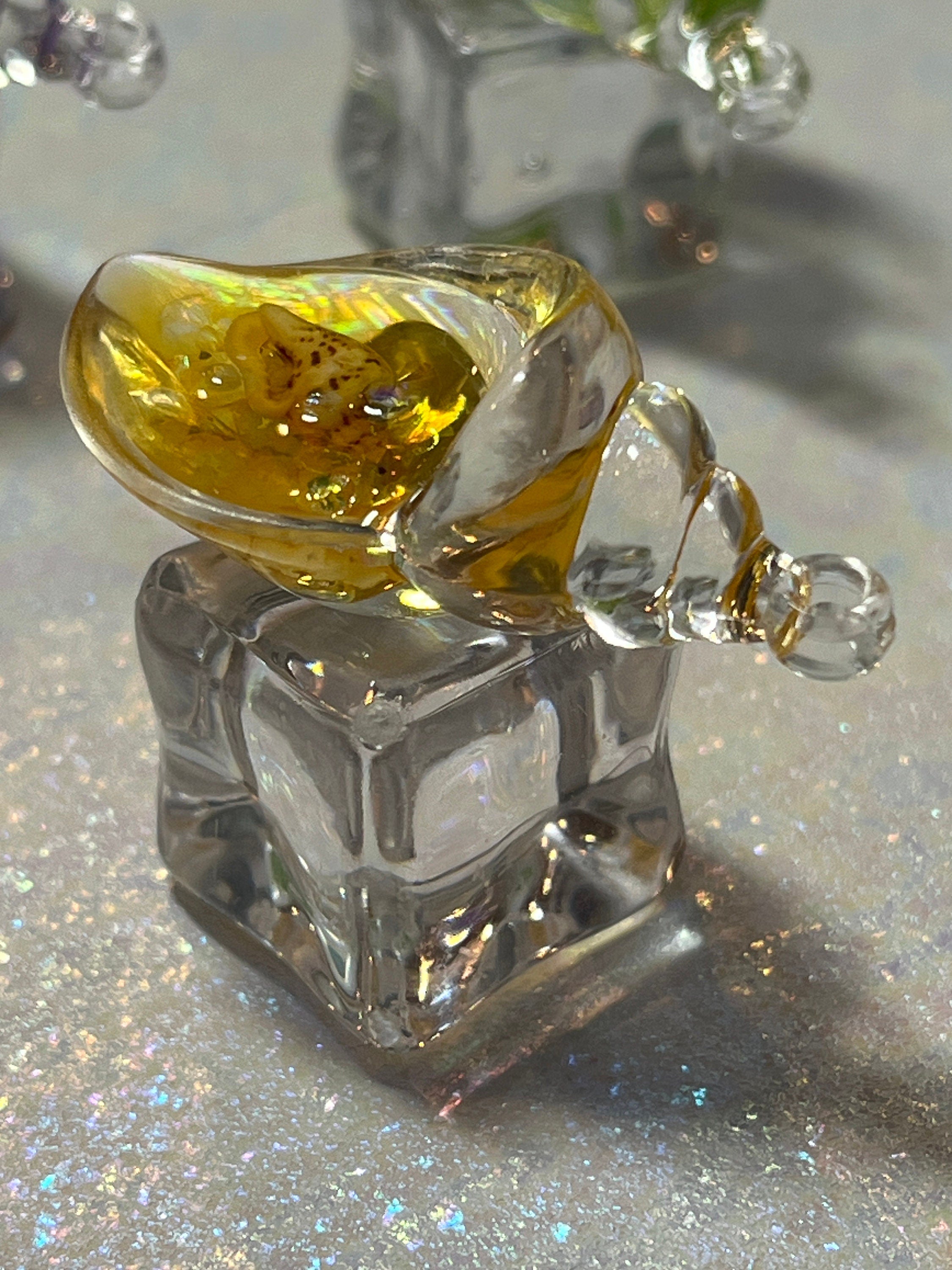 Glass object with a yellow center on a reflective surface