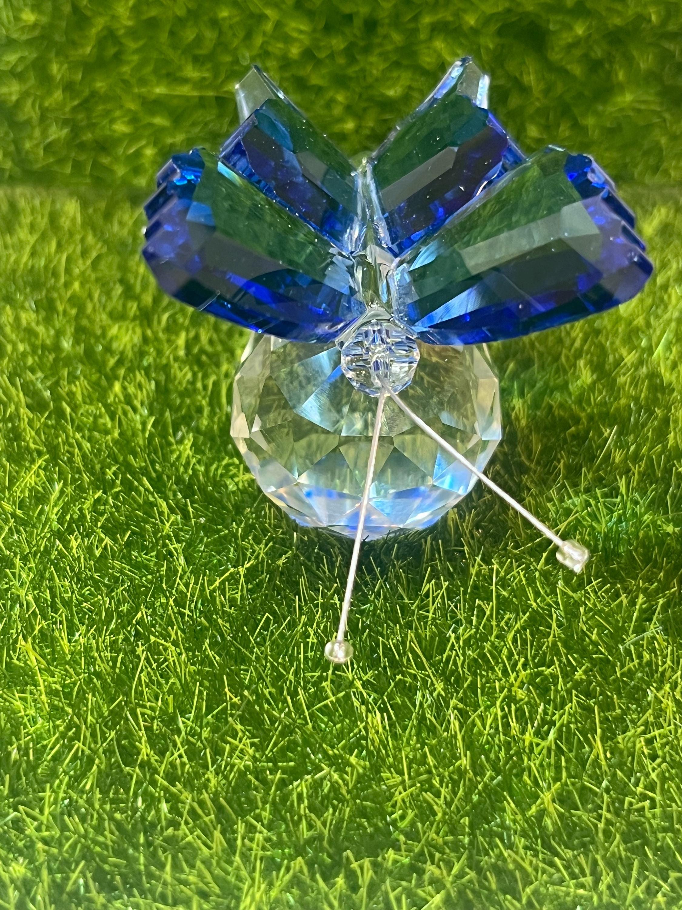 Blue butterfly-shaped object on a green grass background