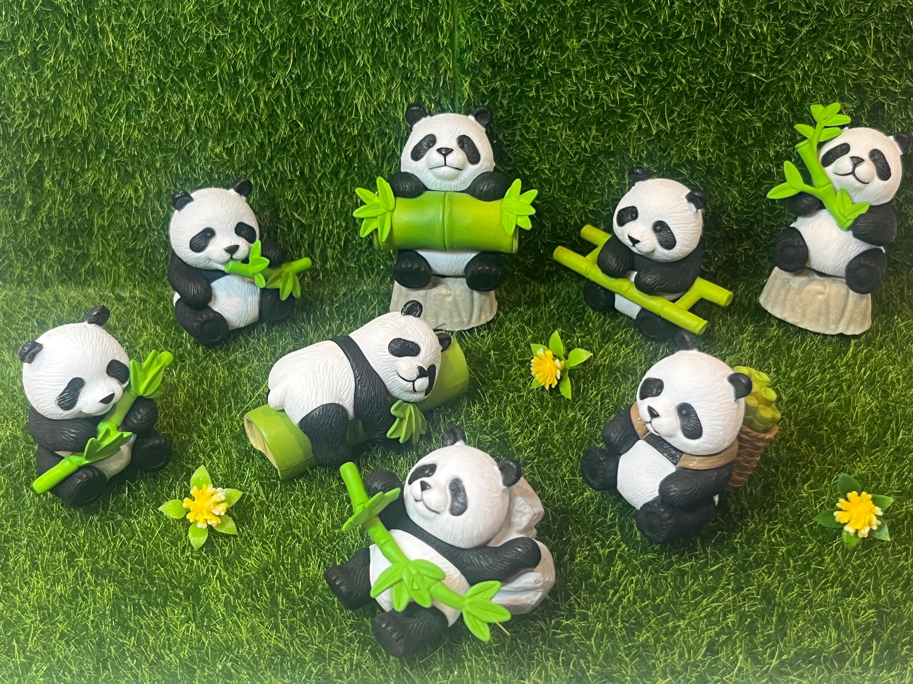 Panda figurines with bamboo on a grassy background