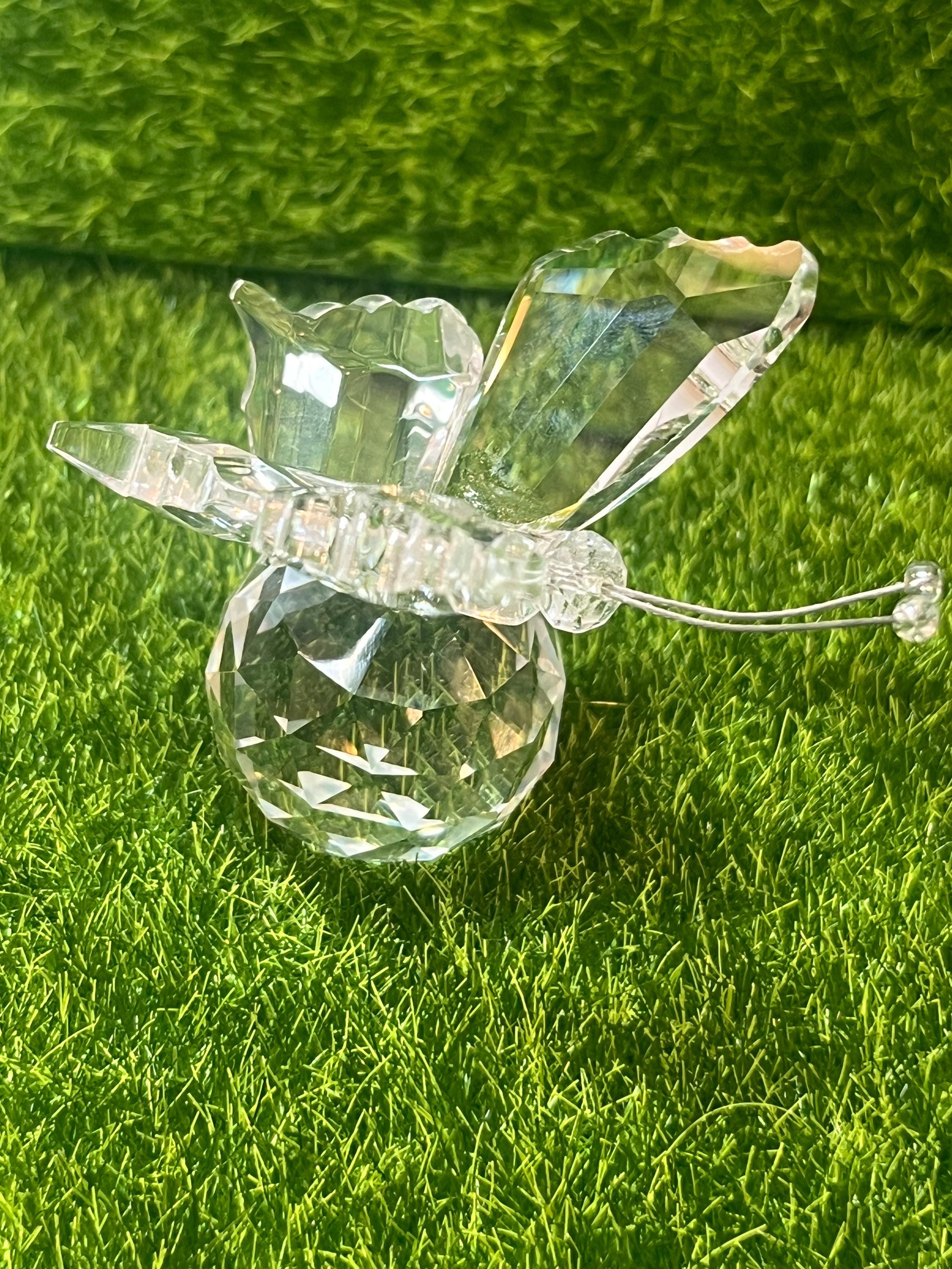 Clear glass butterfly figurine on green grass