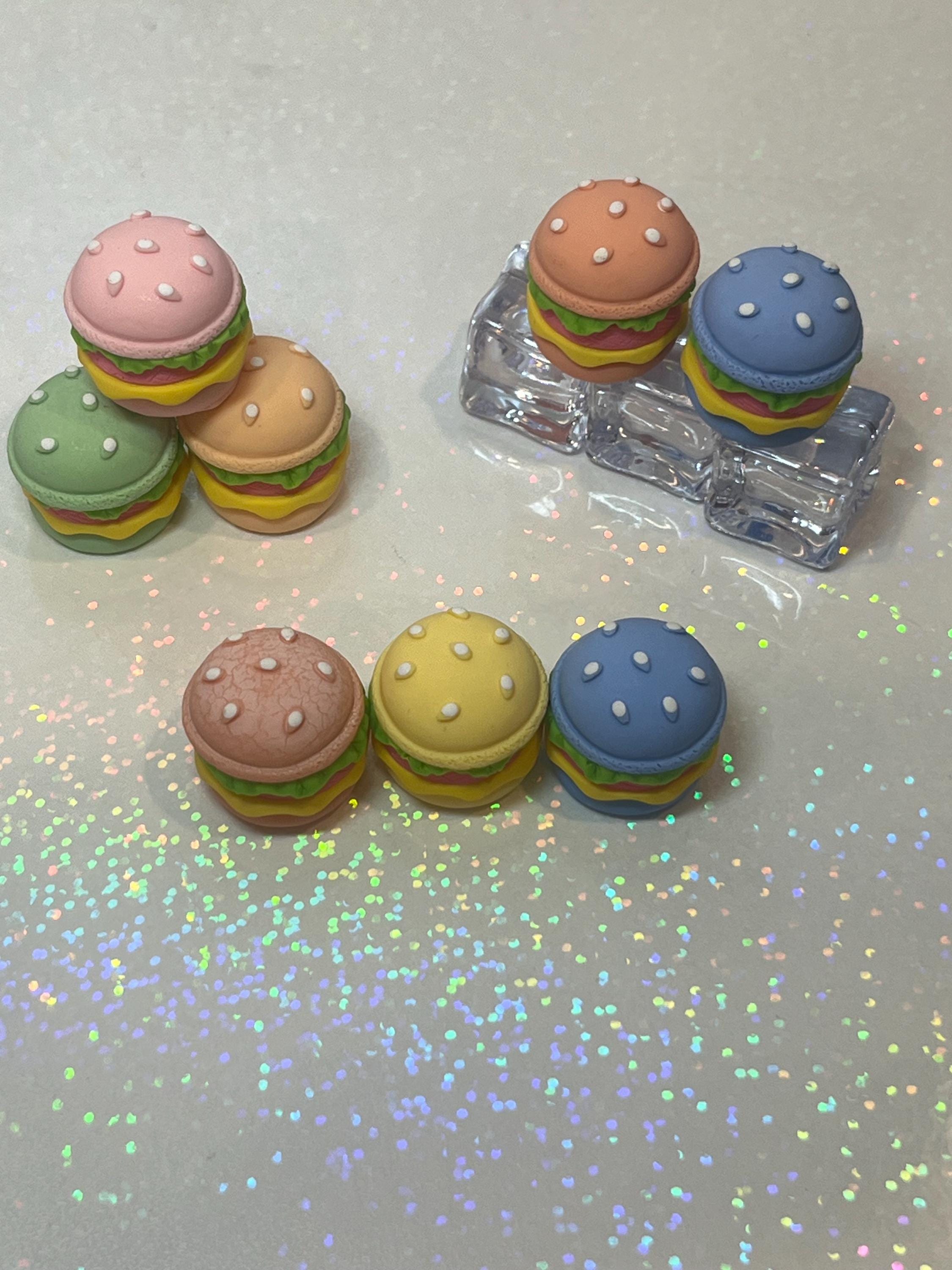 Colorful hamburger-shaped erasers on a glittery surface