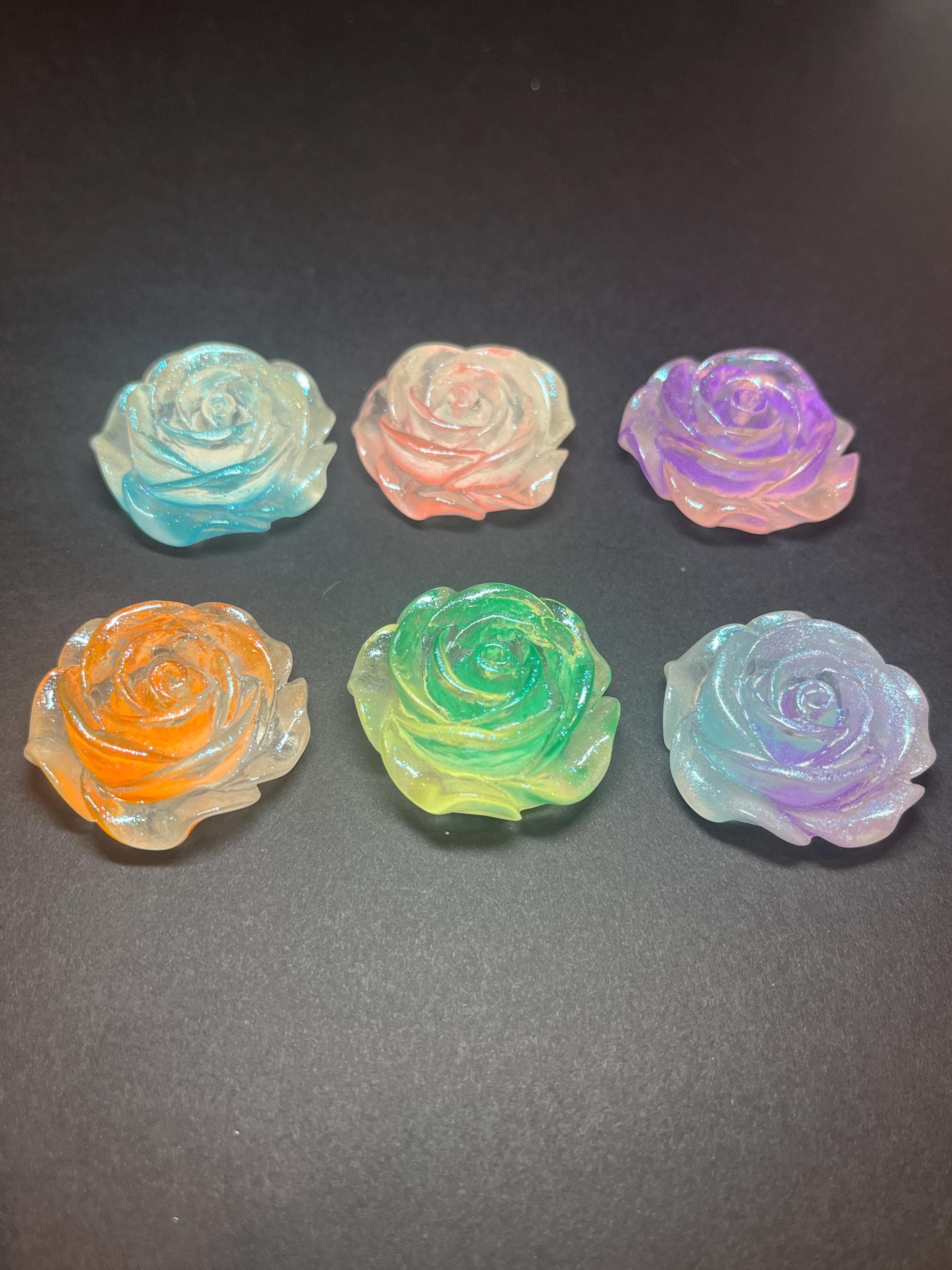 Set of six colorful rose-shaped objects on a dark background