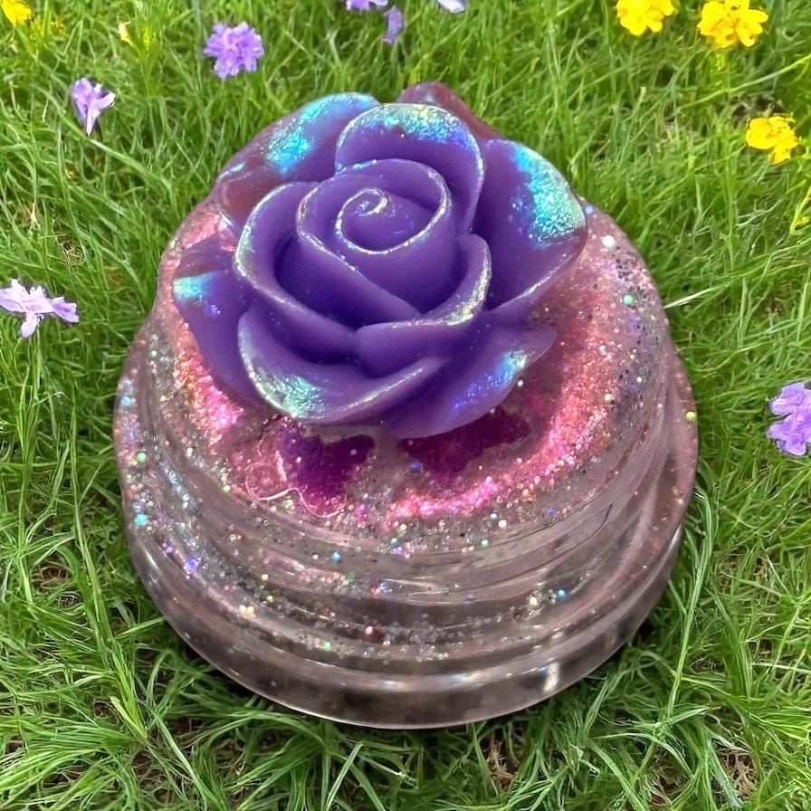 Decorative purple rose with glitter on a grassy background